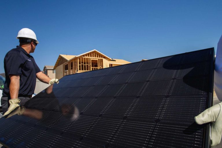 SunStreet workers holding solar panel